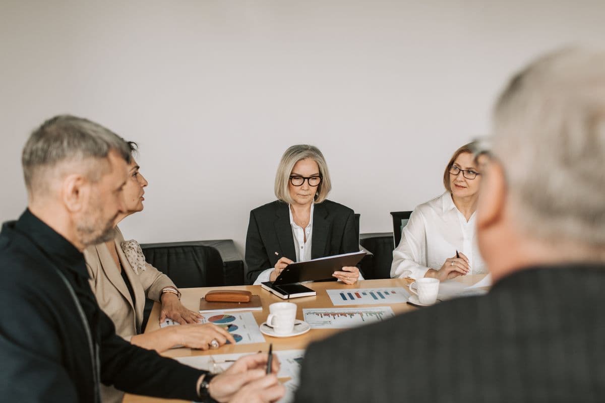 Personnes échangeant autour d’une table de réunion
